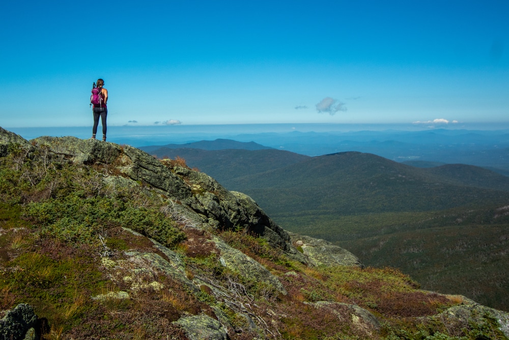 A woman enjoying the view on Mount Washington, one of the most popular places to go hiking in New Hampshire